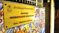 La targa del Centro missionario, circondata dai murales, in via Bardet 